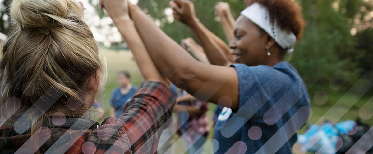 Women link hands, arms raised