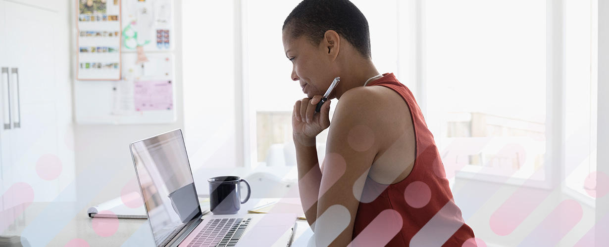 A woman researches information about breast cancer on a laptop